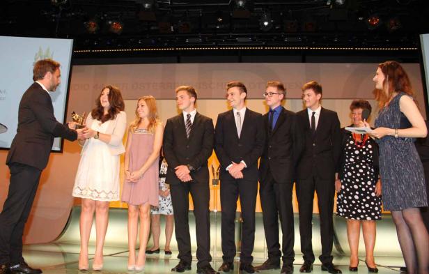 Eine Gruppe junger Leute steht auf einer Bühne und erhält eine Auszeichnung.