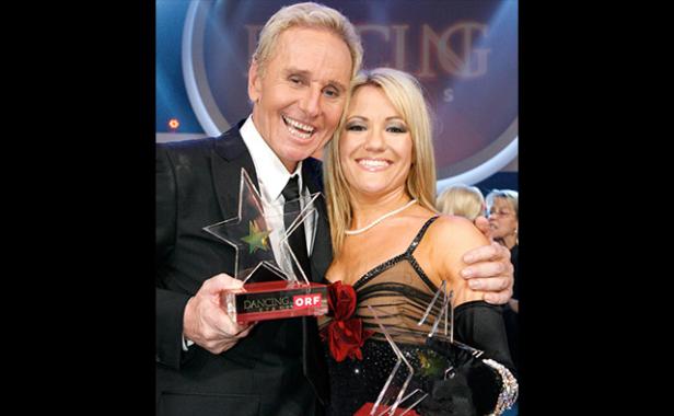 Ein Mann und eine Frau halten Trophäen bei der Show „Dancing Stars“.