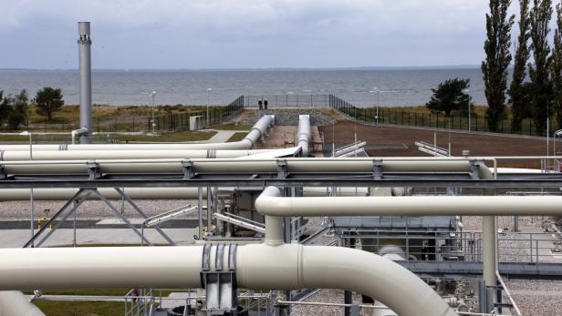 Blick auf eine Gaspipeline mit zwei Personen im Hintergrund vor dem Meer.