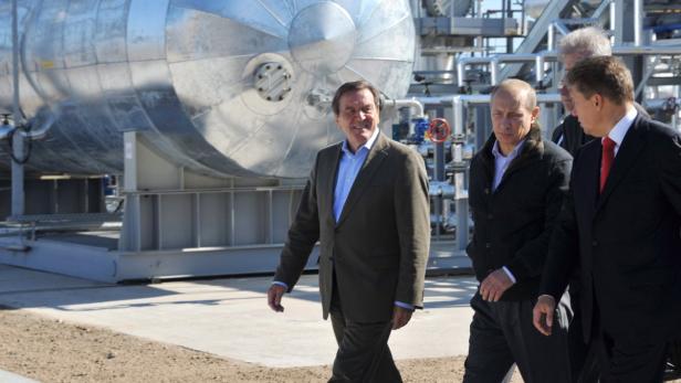 Gerhard Schröder und Wladimir Putin gehen an einer Industrieanlage entlang.