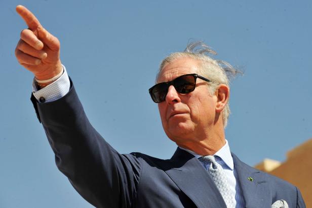 König Charles zeigt mit dem Finger in die Ferne.
