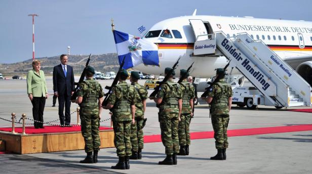 Angela Merkel und Antonis Samaras bei einer Militärparade vor einem Flugzeug der Bundesrepublik Deutschland.