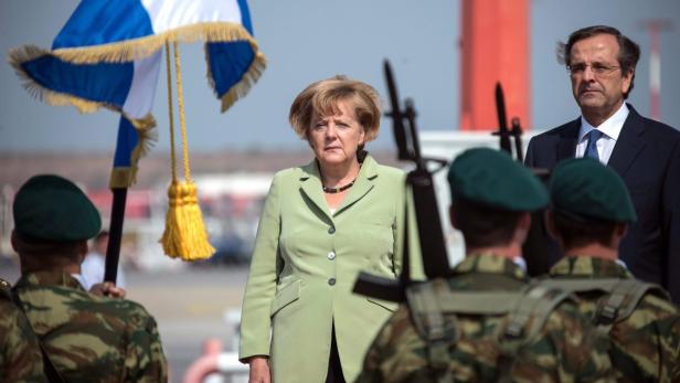 Angela Merkel bei einem offiziellen Empfang mit griechischer Flagge und Soldaten.