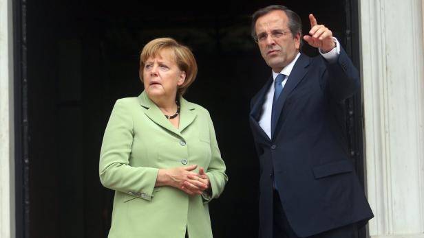 Angela Merkel und Antonis Samaras stehen zusammen vor einer Tür.