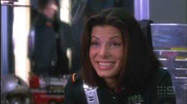 Sandra Bullock lächelt in ihrer Rolle als Polizistin im Film „Speed“.