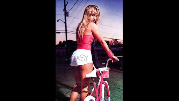 Britney Spears posiert mit einem pinkfarbenen Kinderfahrrad.
