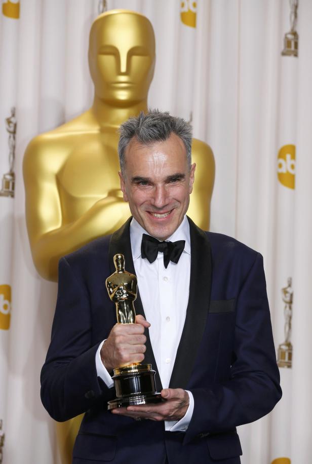 Daniel Day-Lewis hält eine Oscar-Statue in den Händen.