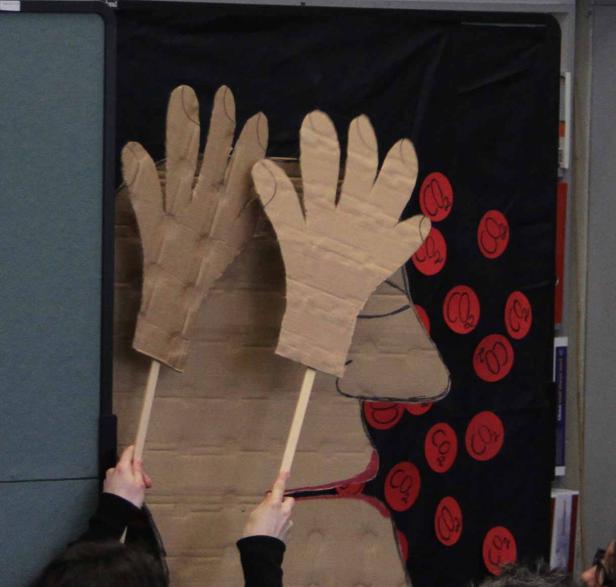 Eine Darstellung des Gasaustauschs in der Lunge mit Papphänden und CO2-Symbolen.