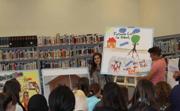 Schüler präsentieren ihre Kunstwerke zum Thema „Frische Luft“ in einer Bibliothek.