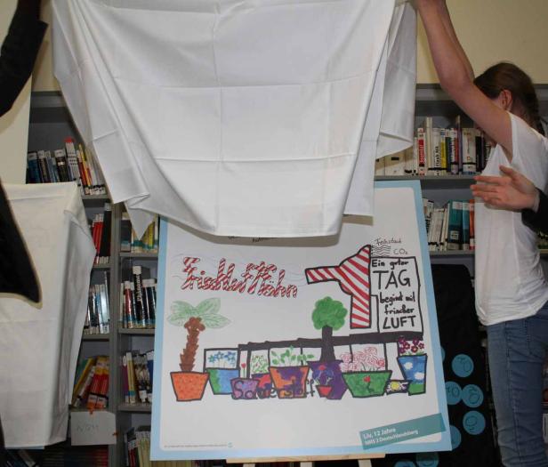 Ein Schülerplakat zum Thema „Frische Luft“ wird enthüllt.