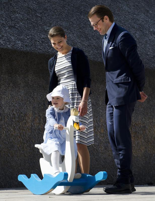 Prinzessin Estelle reitet auf einem Schaukel-Schwan, während ihre Eltern zusehen.