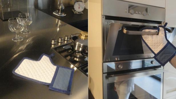 Ein Topflappen liegt auf einer Küchentheke, während ein anderer zum Öffnen eines Ofens verwendet wird.