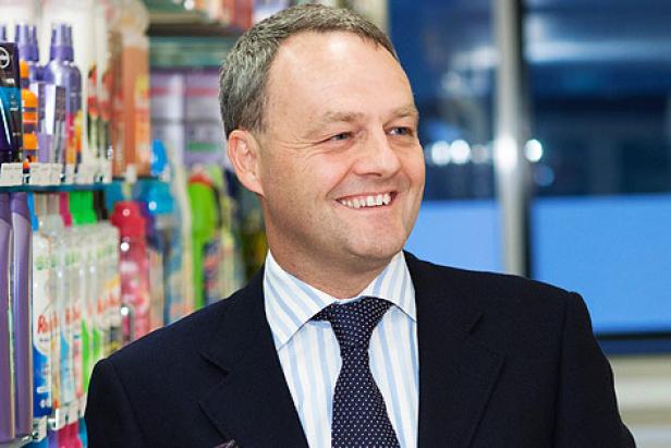 Jan Zijderveld, Unilevers Europa-Chef Ein Mann im Anzug steht vor einem Regal mit Reinigungsmitteln.