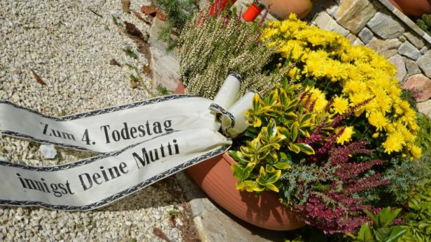 Ein Blumengesteck mit einer Schleife „Zum 4. Todestag, innigst Deine Mutti“.