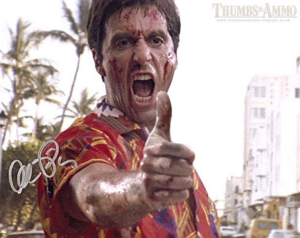 Ein blutverschmierter Mann im Hemd mit Daumen hoch, möglicherweise aus dem Film „Scarface“.