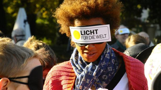 Eine Frau trägt eine Augenbinde mit der Aufschrift „Licht für die Welt“.