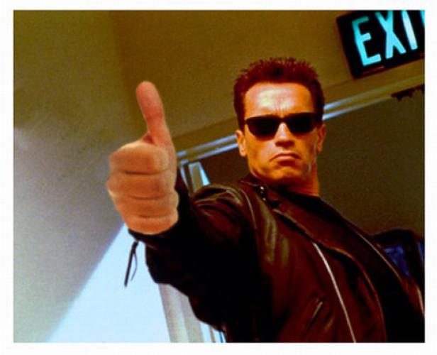 Arnold Schwarzenegger als Terminator mit Sonnenbrille und erhobenem Daumen.