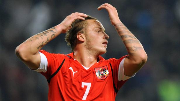 Ein österreichischer Fußballspieler mit Tattoos am Arm im roten Trikot mit der Nummer 7.