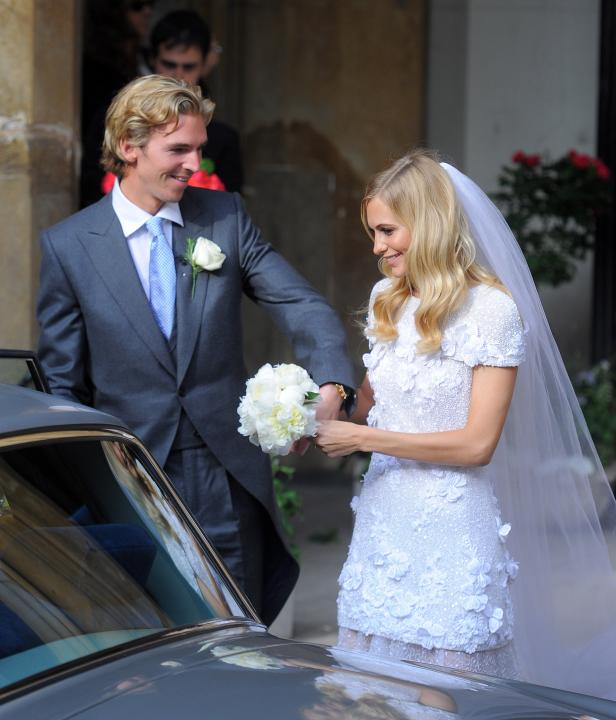 Ein Brautpaar verlässt die Kirche nach der Hochzeit und steigt in ein Auto.