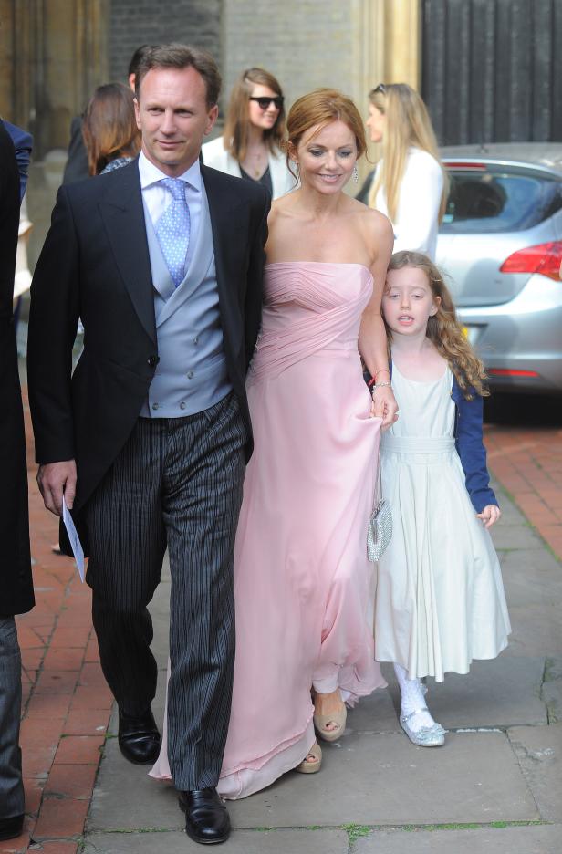 Geri Halliwell in einem rosa Kleid mit Mann und Tochter.
