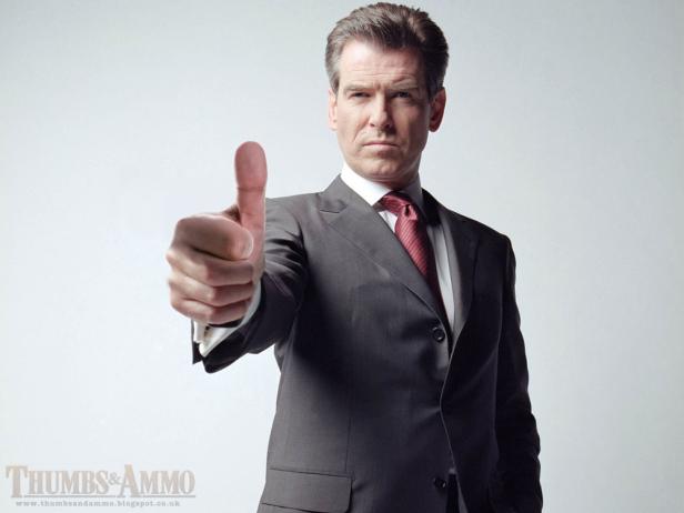 Pierce Brosnan im Anzug zeigt den Daumen nach oben.