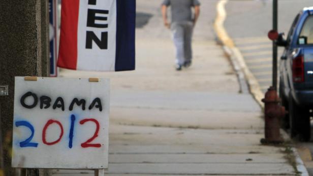 Ein Schild mit der Aufschrift „Obama 2012“ steht auf einem Bürgersteig.