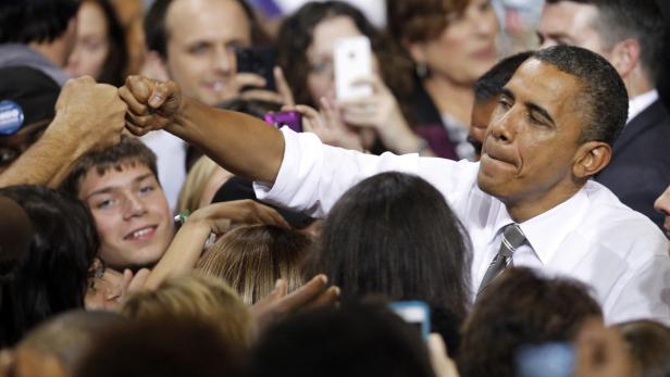 Barack Obama gibt einem Fan ein Faustzeichen in einer Menschenmenge.