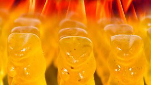 Gelbe Gummibärchen stehen vor einem roten und gelben Hintergrund.