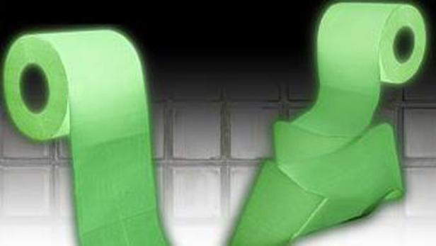 Zwei Rollen leuchtendes, grünes Toilettenpapier vor einem dunklen Hintergrund.