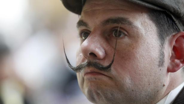 Ein Mann mit Hut und einem extravaganten Schnurrbart.