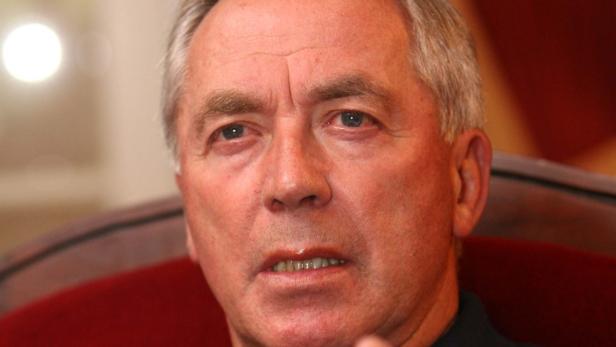 Porträt eines Mannes mit grauen Haaren und blauen Augen.