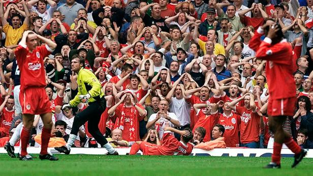 Fußballspieler und entsetzte Fans während eines Spiels.