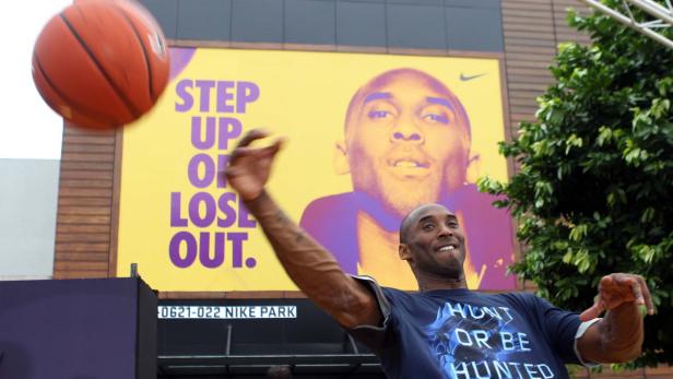 Kobe Bryant wirft einen Basketball vor einem Werbeplakat für Nike Park.