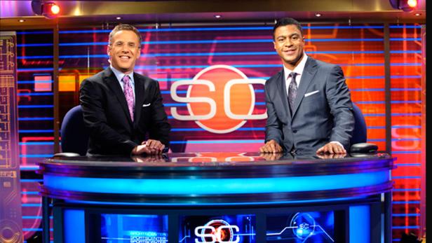 Zwei Moderatoren präsentieren eine Sportnachrichtensendung vor einem „SC“-Logo.