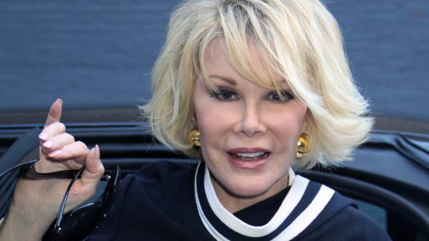 Joan Rivers mit blonden Haaren und goldenen Ohrringen.