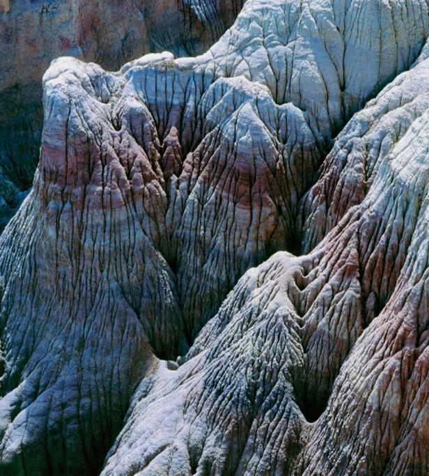 Erosion hat tiefe Furchen in eine Hügellandschaft aus hellem Gestein gegraben.