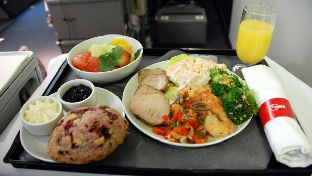 Ein Tablett mit einer Mahlzeit, bestehend aus Fleisch, Salat, Obst und einem Getränk.