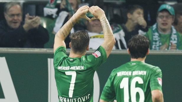 Ein Werder Bremen-Spieler formt mit seinen Händen ein Herz in Richtung der Zuschauerränge.