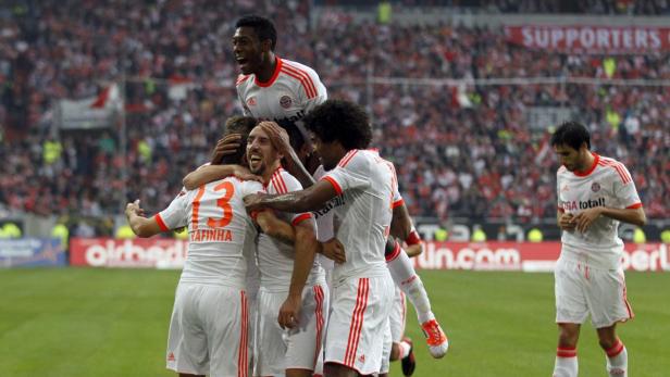 Spieler des FC Bayern München feiern ein Tor auf dem Rasen.