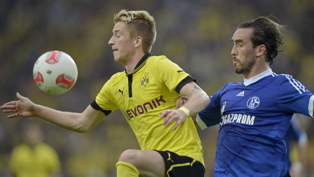Marco Reus von Borussia Dortmund im Zweikampf mit einem Spieler von Schalke 04.