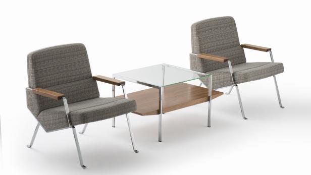 Zwei graue Sessel und ein Tisch mit Glasplatte stehen auf einem weißen Hintergrund.
