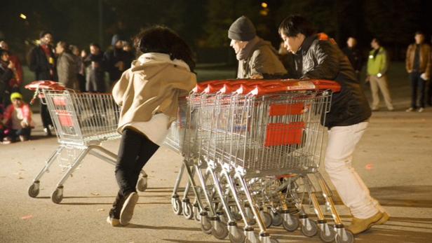 Mehrere Personen schieben Einkaufswagen bei einem ungewöhnlichen Rennen.