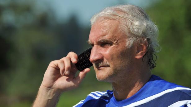 Ein älterer Mann telefoniert mit einem schwarzen Mobiltelefon.