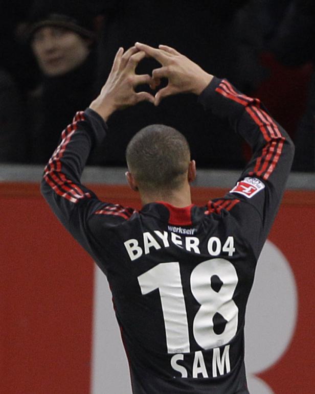 Ein Fußballspieler von Bayer 04 formt mit seinen Händen ein Herz.