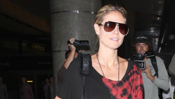 Heidi Klum mit Sonnenbrille wird von Paparazzi mit Kameras fotografiert.