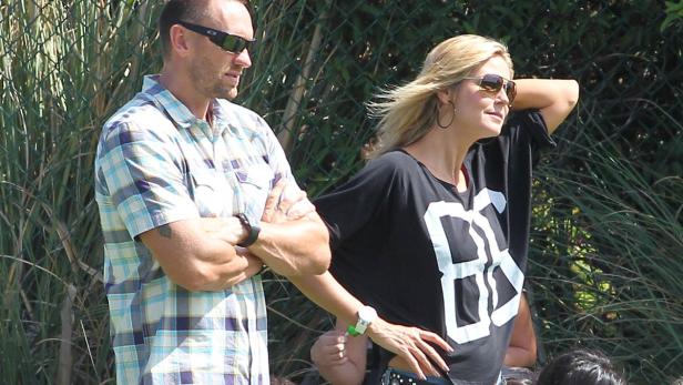 Ein Mann mit Sonnenbrille und kariertem Hemd steht neben einer blonden Frau mit Sonnenbrille.