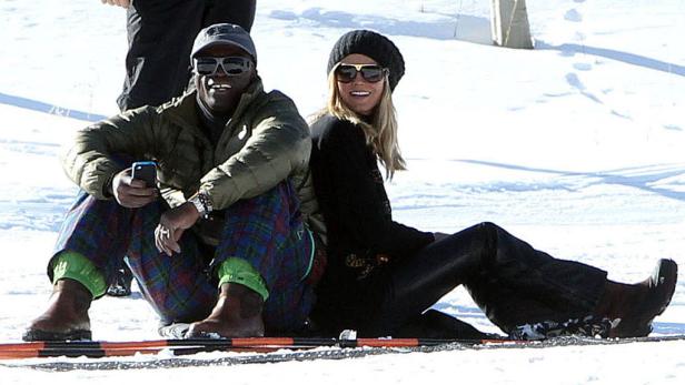 Heidi Klum und Seal sitzen im Schnee.