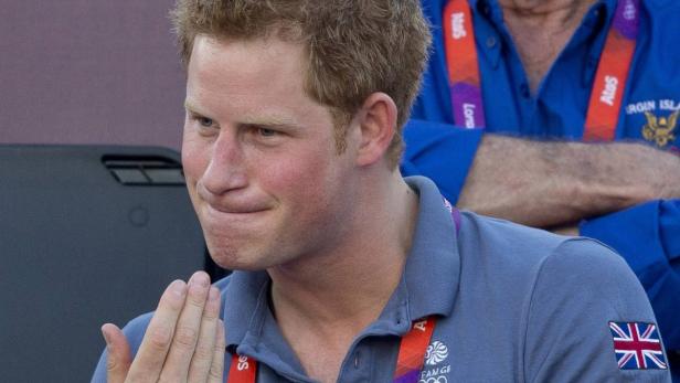 Prinz Harry bei einer Veranstaltung mit britischer Flagge auf seinem Poloshirt.