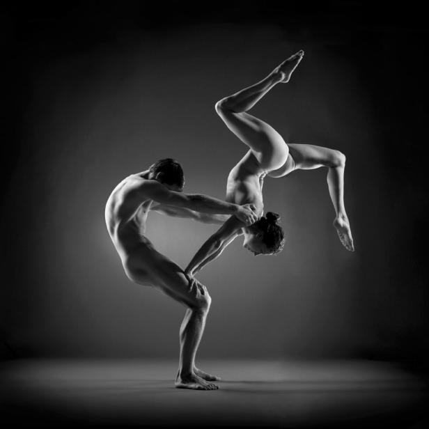 Ein Mann unterstützt eine Frau in einer akrobatischen Pose.