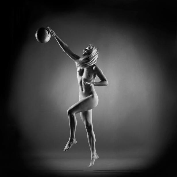 Eine Frau springt und spielt mit einem Volleyball.